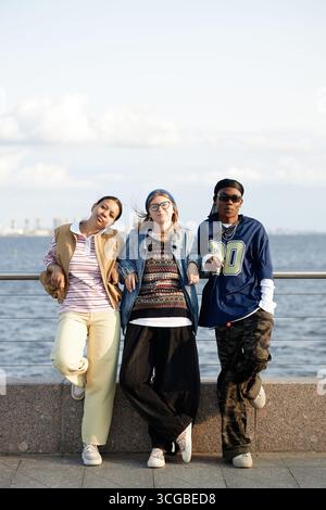 Multiethnische Gruppe junger Erwachsener, die am Ufer stehen und im Freien lächeln Stockfoto