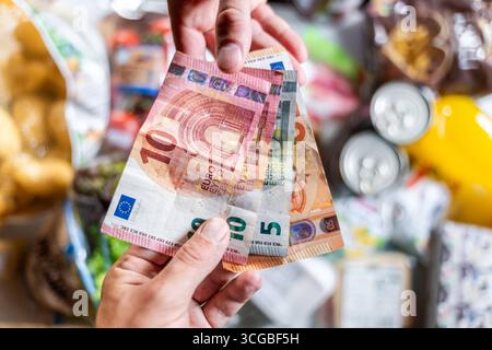Bayern, Deutschland - 27. August 2025: Ein Kunde bezahlt seinen Lebensmitteleinkauf im Supermarkt in Bargeld mit Euro-Banknoten, Bargeld *** ein Kunde bezahlt seinen Lebensmitteleinkauf im Supermarkt bar mit Euro-Geldscheinen, Bargeld Stockfoto