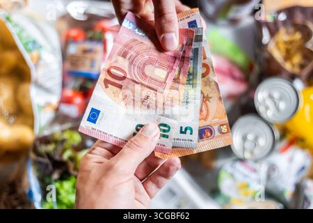 Bayern, Deutschland - 27. August 2025: Ein Kunde bezahlt seinen Lebensmitteleinkauf im Supermarkt in Bargeld mit Euro-Banknoten, Bargeld *** ein Kunde bezahlt seinen Lebensmitteleinkauf im Supermarkt bar mit Euro-Geldscheinen, Bargeld Stockfoto