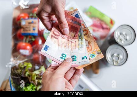 Bayern, Deutschland - 27. August 2025: Ein Kunde bezahlt seinen Lebensmitteleinkauf im Supermarkt in Bargeld mit Euro-Banknoten, Bargeld *** ein Kunde bezahlt seinen Lebensmitteleinkauf im Supermarkt bar mit Euro-Geldscheinen, Bargeld Stockfoto