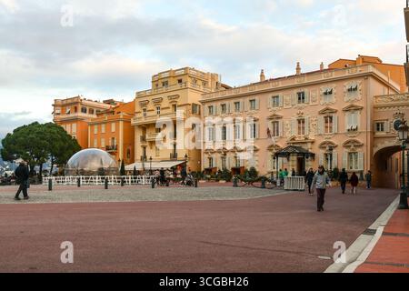 Blick auf den Place du Palais (Palastplatz) mit Weihnachtsdekoration und Wanderungen durch Touristen, im Winter bei Sonnenuntergang, Monaco Ville, Fürstentum Monaco Stockfoto