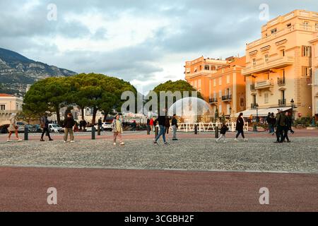 Blick auf den Place du Palais (Palastplatz) mit Weihnachtsdekoration und Wanderungen durch Touristen, im Winter bei Sonnenuntergang, Monaco Ville, Fürstentum Monaco Stockfoto