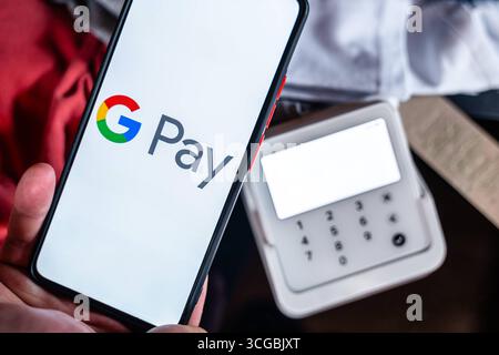 Bayern, Deutschland - 27. August 2025: Ein Smartphone mit dem Google Pay-Logo vor einem EC-Terminal *** ein Smartphone mit Google-Pay-Logo vor einem EC-Terminal im Einzelhandel Stockfoto