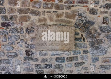 Mittelalterliche Mauermauer in Erdtönen mit einer Tafel Stockfoto