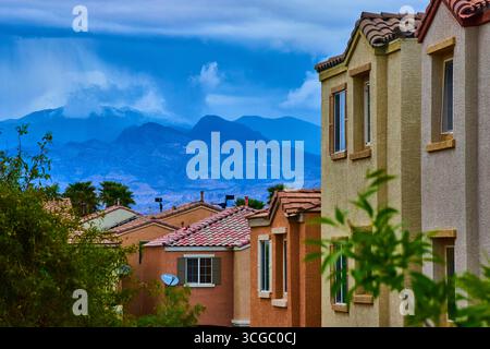 Vorstädtische Häuser in Las Vegas mit Stormy Mountains und üppigem Grün Stockfoto