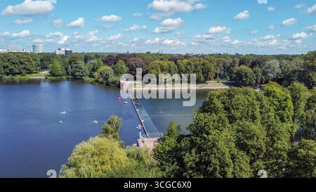 Blick aus der Vogelperspektive auf den Hamburger Stadtpark mit Teich, Leute auf Tretbooten, Paddelbretter und Kajaks (Boot) im Wasser im Sommer in Hamburg, einige Schwimmer - Stockfoto