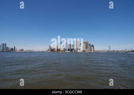 Weitwinkelblick auf die Skyline von Lower manhattan von der anderen Seite des New York Harbor auf Governors Island mit klarem blauem Himmel, Kopierraum Stockfoto