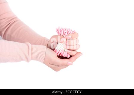 Junge Frau mit rosafarbenen Wattestäbchen vor weißem Hintergrund. Kopierbereich. Stockfoto