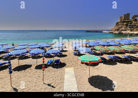 247 Aurora Tower auf dem Hügel San Cristoforo mit Blick auf die gestreiften Sonnenschirme, die die Altstadt - paese antico - Strand W end bedecken Monterosso al Mare-Ligurien Stockfoto