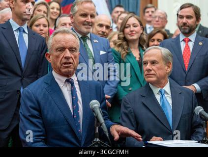 Austin, Usa. August 2025. US-Gesundheitsminister ROBERT F. KENNEDY, JR.(l) spricht vor der Presse im Texas Capitol, als Gouverneur GREG ABBOTT am 27. August 2025 drei gesundheitsbezogene Gesetze unterzeichnet, die Zusatzstoffe regulieren und Wohlfahrtsleistungen für zuckerhaltige Snacks und andere Gesundheitsmaßnahmen verbieten. Quelle: Bob Daemmrich/Alamy Live News Stockfoto