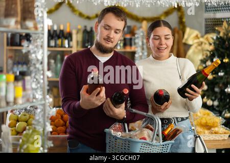 Verheiratetes Paar wählt Alkohol in einem Geschäft mit Interesse Stockfoto