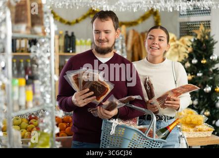 Glückliches Paar, das Würstchen im Laden auswählt Stockfoto