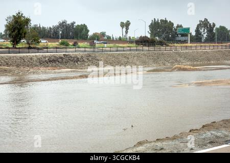 Anaheim, Kalifornien, USA - 13. März 2020: Blick auf den Santa Ana River während eines Regensturms. Der Wasserstand steigt im Kanal. Stockfoto