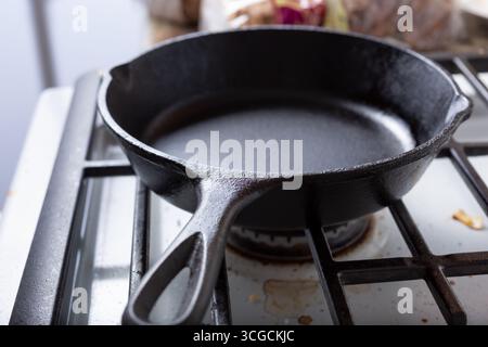 Blick auf eine gusseiserne Pfanne auf einem Herd in einer Küche. Stockfoto