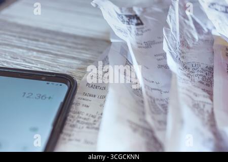 Los Angeles, Kalifornien, USA - 02-06-2020: Eine Nahaufnahme mehrerer Belege und einer Taschenrechner-App, die auf einem Handy verwendet wird. Stockfoto