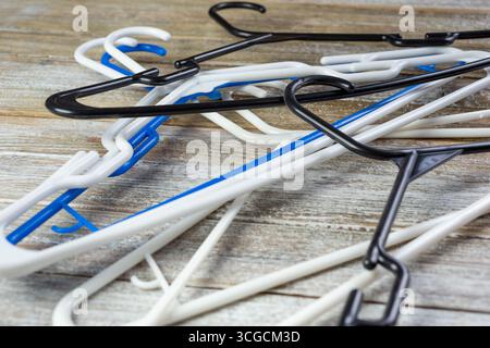 Blick auf einen Stapel von Kunststoffbügeln auf einer Holzoberfläche. Stockfoto