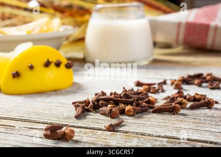 Eine Nahaufnahme mehrerer Stücke getrockneter Nelken auf einer Holzoberfläche, in einem Stillleben. Stockfoto