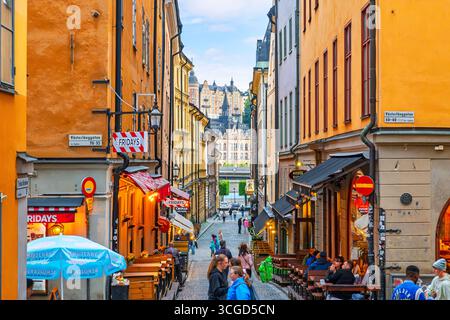 Die enge kopfsteingepflasterte Tyska Brinken Straße voller Geschäfte und Straßencafés im historischen Gamla Stan Viertel in Stockholm Schweden. Stockfoto