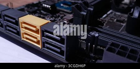 Eine detaillierte Nahaufnahme eines PC-Mainboards mit mehreren SATA III-Ports, darunter einem gelben Anschluss. Hebt die wichtigsten PC-Komponenten hervor Stockfoto