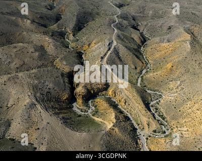 Aus der Vogelperspektive auf gewundene Hügel mit einer gewundenen Straße durch felsige Landschaft, aus der Vogelperspektive, Angel's Canyon, Canyon, Dashtakar, Provinz Ararat, Armenien Stockfoto