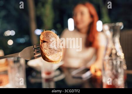 Traditionelle kasachische Pferdefleischwurst namens Kazy, serviert auf einer Gabel in einem Restaurant. Stockfoto