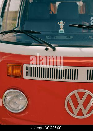 Ein klassischer VW-Wohnmobil im Retro-Stil mit einer sommerlich tanzenden Plastikfigur – Roadtrip im Sommer Stockfoto