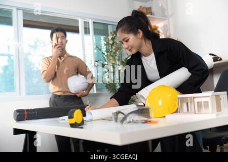 Ingenieure prüfen Baupläne und -Modelle Stockfoto