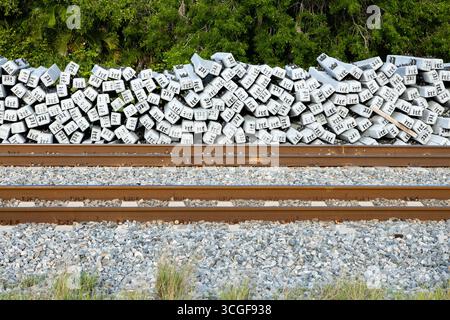 Eisenbahnverbindungen, die von einem Eisenbahngleis gestapelt sind Stockfoto