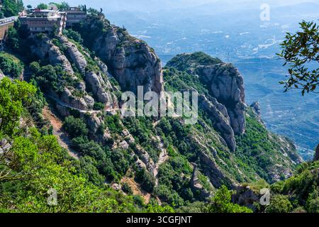 Blick auf den gepflasterten Fußweg, der zum Benediktinerkloster Santa Maria de Montserrat führt, das sich in der spanischen Region Katalonien befindet Stockfoto