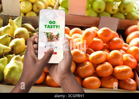 Lieferung von Lebensmitteln. Mann mit Handy-App, um Lebensmittel online zu bestellen, Nahaufnahme Stockfoto