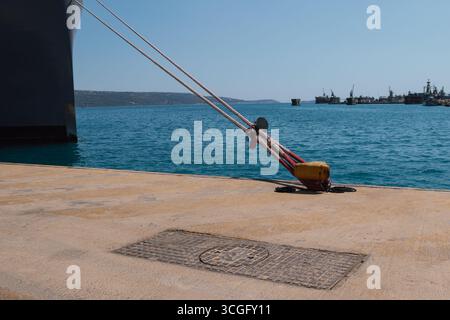 Festmachen eines Schiffes im Hafen mit Festmacherleinen an einem Schiffspoller am Kai Stockfoto