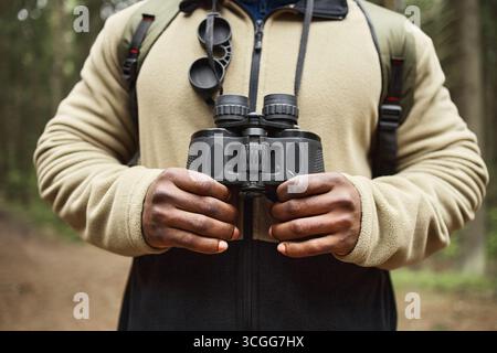 Schwarzer Mann Mittleren Alters Hält Ferngläser Bei Der Erkundung Des Waldes Im Freien Stockfoto