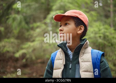 Preteen Black Boy erkundet den Wald während eines Outdoor-Abenteuers in der Natur Stockfoto