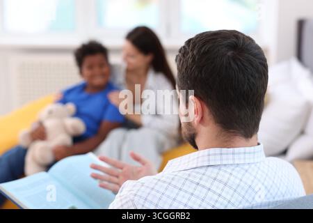 Vater liest seiner Familie zu Hause Geschichte vor, selektiver Fokus Stockfoto