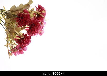 Ein Haufen roter künstlicher Blumen isoliert auf weißem Hintergrund. Stockfoto