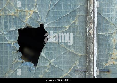 Kaputtes, verstärktes industrielles Glasfenster. Stockfoto