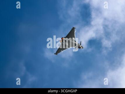 Militärjäger Eurofighter F-2000A Taifun fliegt in einem klaren blauen Himmel mit eingespielten Nachbrennern und zeigt Geschwindigkeit und Leistung auf der RIAT 2025 Stockfoto