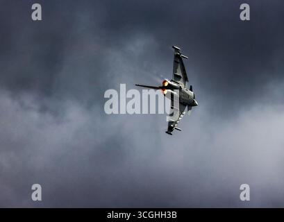 Jet Fighter in einem dynamischen vertikalen Aufstieg gegen einen stürmischen Himmel mit Nachbrennern im Vollbild. Eurofighter F-2000A Typhoon auf RIAT 2025 Stockfoto