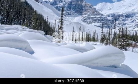 Großer, mit Schnee bedeckter Felsen und Bergkamm im Hintergrund Stockfoto