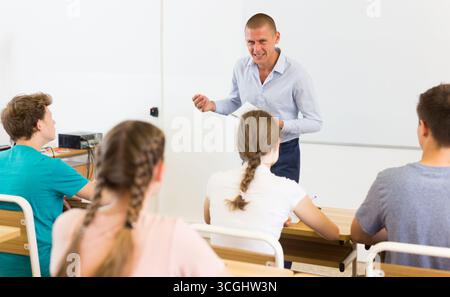 Männlicher Lehrer, der Teenager-Studenten im Auditorium vorträgt Stockfoto