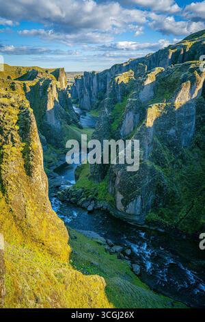 Steile, moosbedeckte Klippen und ein sich windender Fluss durchziehen den dramatischen Fjaðrárgljúfur Canyon im Süden Islands Stockfoto