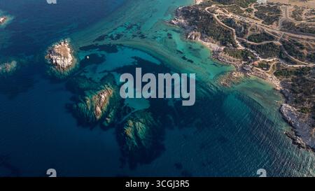 Die Luftperspektive fängt die faszinierende Schönheit von Toroni in Griechenland ein und zeigt kristallklares türkisfarbenes Wasser, das sanft über eine felsige Küste fließt Stockfoto