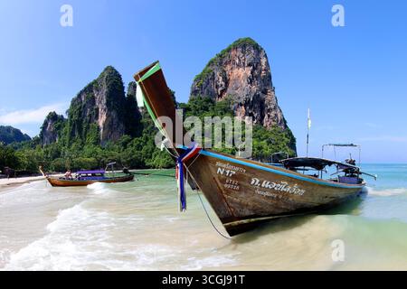 Kalksteinklippen am West Railay Beach mit Langschwanzbooten, Krabi, Thailand Stockfoto
