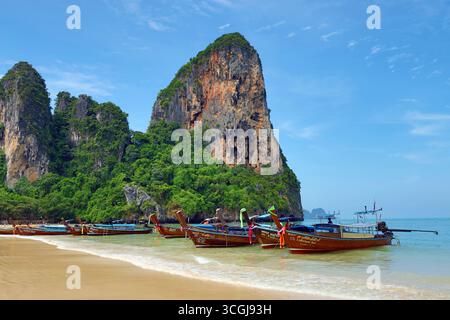 Kalksteinklippen am West Railay Beach mit Langschwanzbooten, Krabi, Thailand Stockfoto