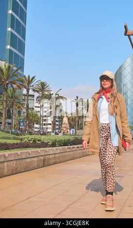 Touristenwanderung in miraflores, lima, mit modernen Gebäuden, Palmen und El Beso Statue im Hintergrund Stockfoto