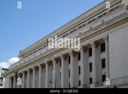 Niedrigwinkelaufnahme des großen neoklassizistischen Gebäudes der rumänischen Nationalbank in Bukarest. Die beeindruckende Fassade verfügt über eine Reihe von großen Säulen Stockfoto