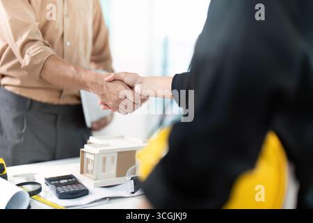 Professionelle Vereinbarung. Ingenieur und Architekt schütteln sich die Hände beim Projekt. Stockfoto
