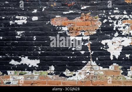 Nahaufnahme abstrakter Texturhintergrund einer grungy alten Backsteinaußenwand, die mit mehrfarbiger abblätternder Farbe bedeckt ist Stockfoto