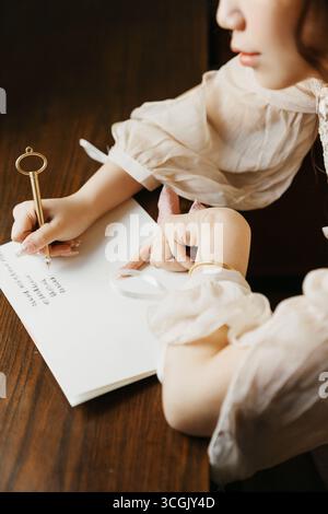 Chinesische Schreibarbeit Nahaufnahme: Frau mit Goldstift auf Notizbuch Stockfoto