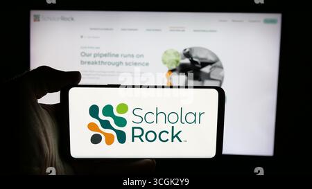 In dieser Abbildung hält eine Person ein Handy mit dem Logo der US-amerikanischen Firma Scholar Rock Holding Corporation auf dem Bildschirm vor der Webseite. Stockfoto